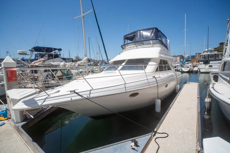 Slide: The Image of 1996 CRUISERS YACHTS 3580 Flybridge docked at marina under clear blue sky. - 25