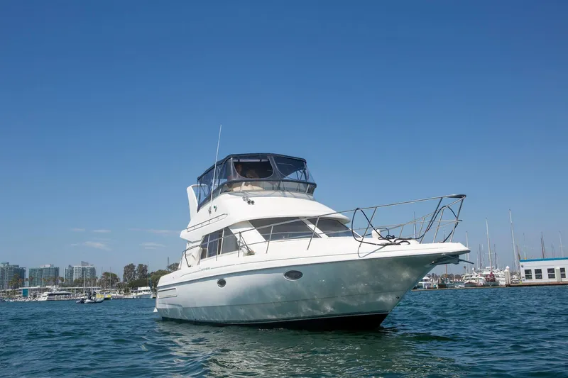Slide: The Image of 1996 CRUISERS YACHTS 3580 Flybridge on water, clear sky, marina background. - 3