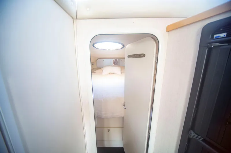 Slide: The Image of Interior cabin view of 1996 CRUISERS YACHTS 3580 Flybridge, featuring a cozy bed and porthole. - 54