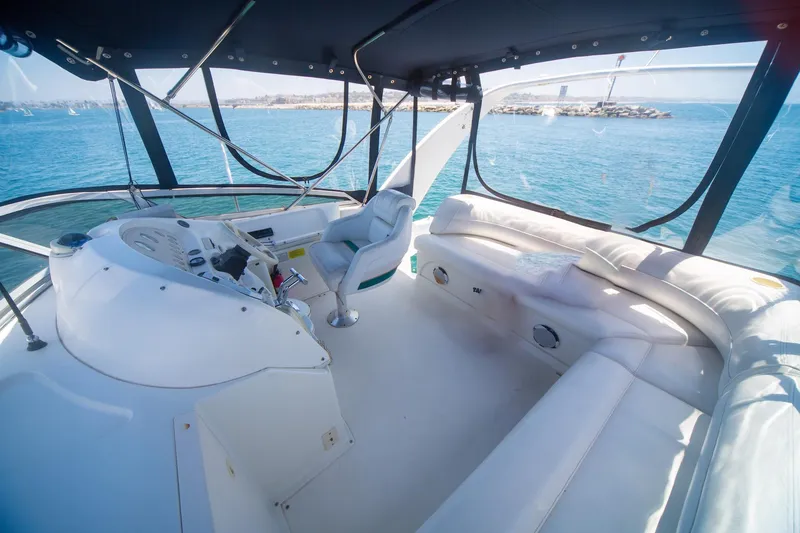 Slide: The Image of 1996 CRUISERS YACHTS 3580 Flybridge interior with helm and seating, overlooking serene ocean view. - 30