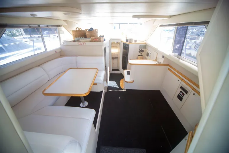 Slide: The Image of Interior of 1996 CRUISERS YACHTS 3580 Flybridge, featuring white seating and dining area. - 42