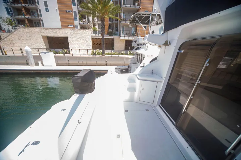 Slide: The Image of 1996 CRUISERS YACHTS 3580 Flybridge docked near modern waterfront buildings. - 37