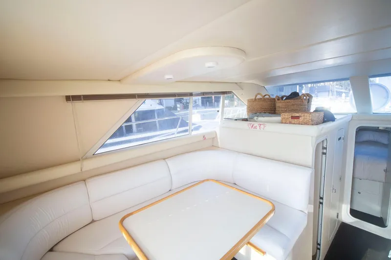 Slide: The Image of Interior of 1996 CRUISERS YACHTS 3580 Flybridge with white seating and dining table. - 50