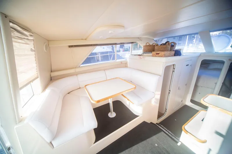 Slide: The Image of Interior of 1996 CRUISERS YACHTS 3580 Flybridge with white seating and dining area. - 48