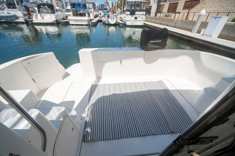 Slide: The Image of 1996 CRUISERS YACHTS 3580 Flybridge, spacious deck with striped rug, docked in marina. - 28