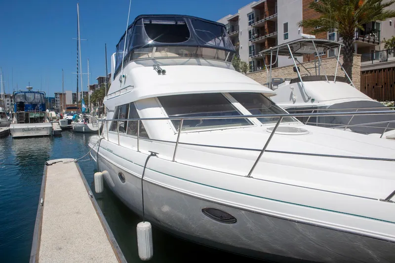 Slide: The Image of 1996 CRUISERS YACHTS 3580 Flybridge docked at marina under clear blue sky. - 13