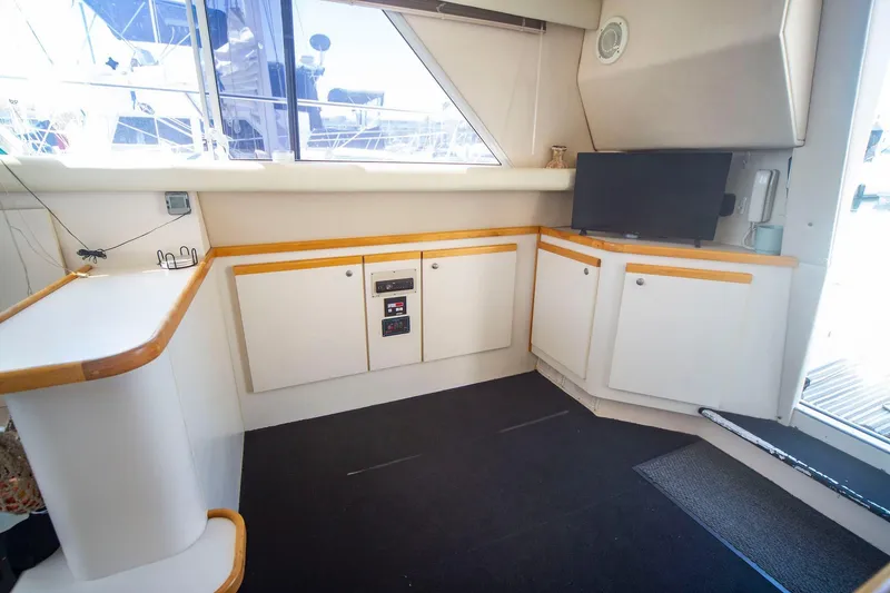 Slide: The Image of Interior of 1996 CRUISERS YACHTS 3580 Flybridge with cabinets and a TV. - 43