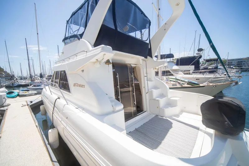 Slide: The Image of 1996 CRUISERS YACHTS 3580 Flybridge docked at marina under clear blue sky. - 22