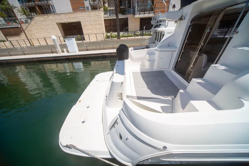 Slide: The Image of 1996 CRUISERS YACHTS 3580 Flybridge docked, showcasing spacious deck and sleek design. - 27