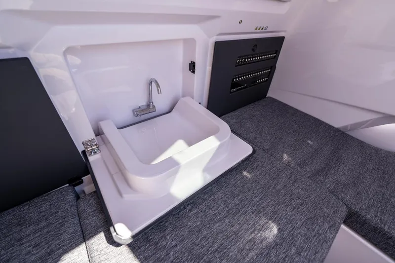 Slide: The Image of Interior of 2027 Axopar 29 Sun-Top featuring a compact sink and control panel. - 20