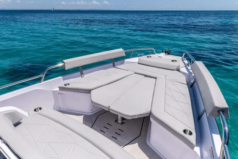 Slide: The Image of 2027 Axopar 29 Sun-Top boat with spacious seating on clear blue water. - 11