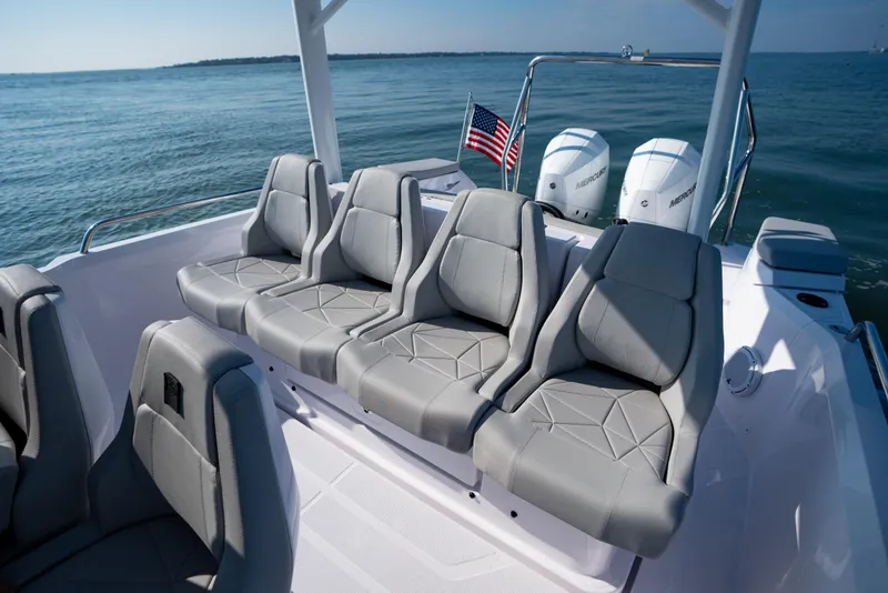 Slide: The Image of 2027 Axopar 29 Sun-Top boat with gray seating, American flag, and twin Mercury engines. - 14