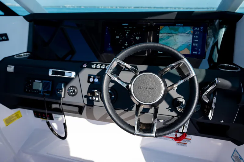 Slide: The Image of Steering wheel and dashboard of 2027 Axopar 29 Sun-Top boat with navigation displays. - 16