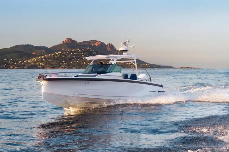 The Image of 2027 Axopar 29 Sun-Top cruising on scenic coastal waters at sunset. - 0