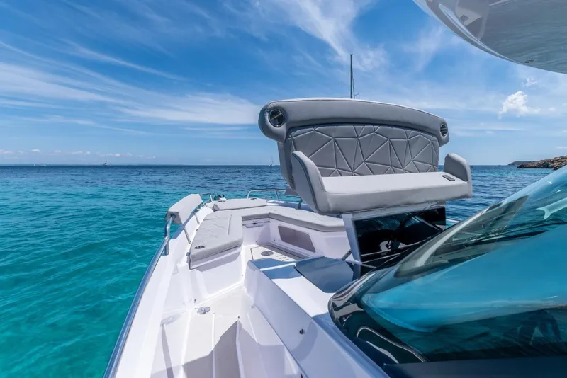Slide: The Image of 2027 Axopar 29 Sun-Top boat on clear blue water under a sunny sky. - 10