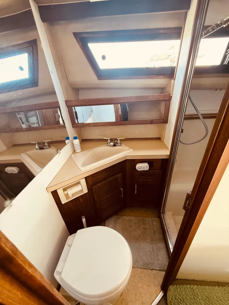 Slide: The Image of 1983 Silverton 402 Motor Yacht bathroom with sink, toilet, and shower. - 24