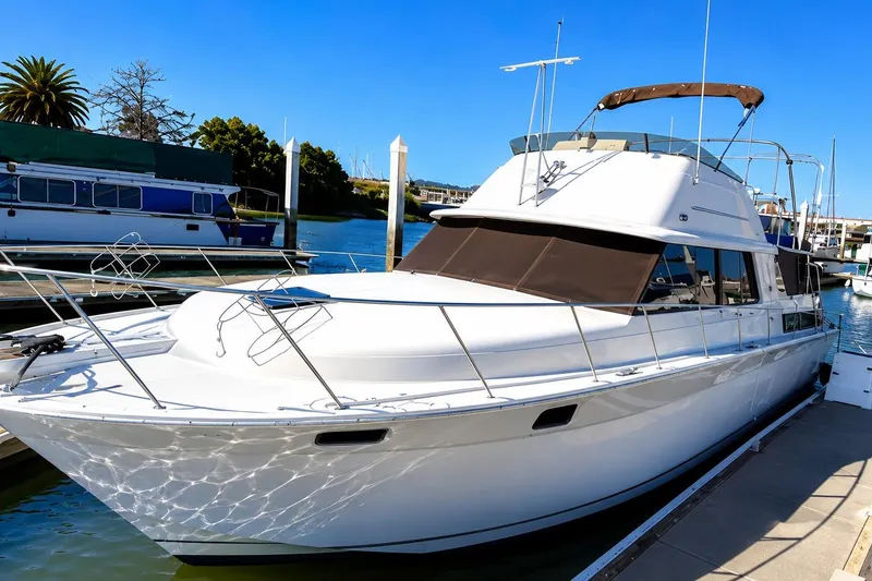 Slide: The Image of 1983 Silverton 402 Motor Yacht docked at marina under clear blue sky. - 0