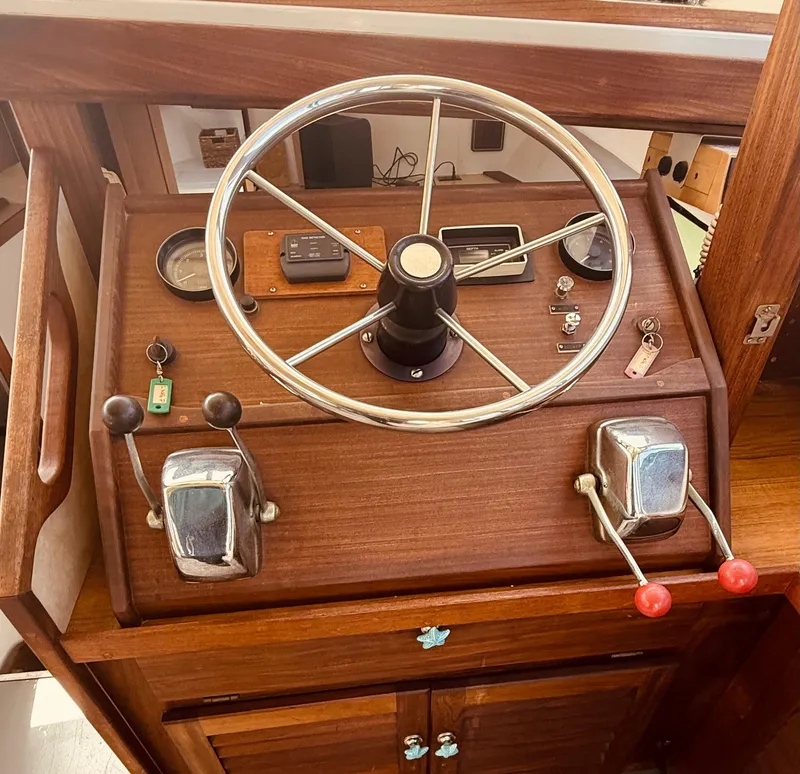 Slide: The Image of 1983 Silverton 402 Motor Yacht helm with wooden dashboard and steering wheel. - 9