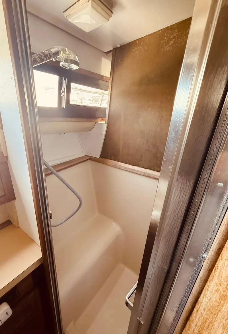 Slide: The Image of 1983 Silverton 402 Motor Yacht shower area with window and chrome fixtures. - 26