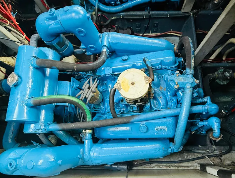 Slide: The Image of Engine of a 1983 Silverton 402 Motor Yacht, painted blue with visible hoses and components. - 29
