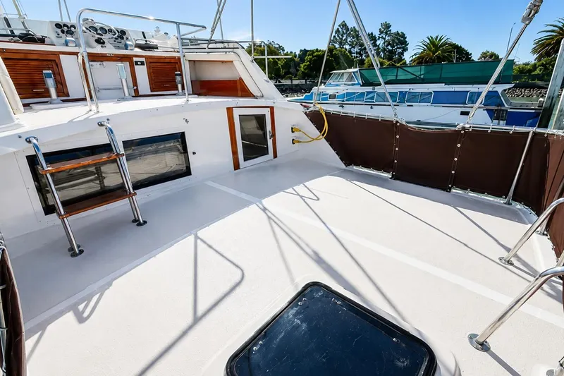 Slide: The Image of 1983 Silverton 402 Motor Yacht deck with railing and ladder, docked near other boats. - 6
