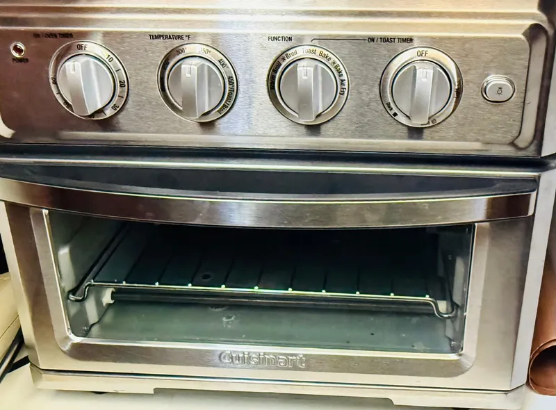Slide: The Image of A stainless steel Cuisinart toaster oven with multiple control knobs. - 16