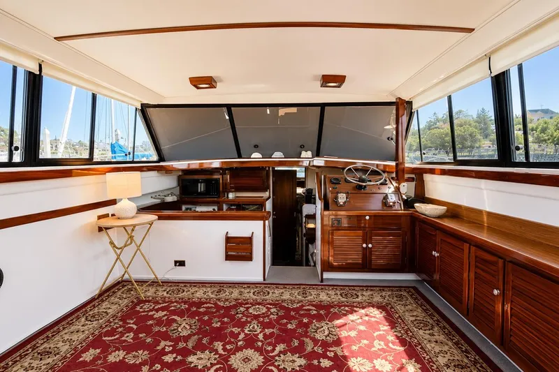 Slide: The Image of Interior of 1983 Silverton 402 Motor Yacht with elegant wood finishes and large windows. - 13