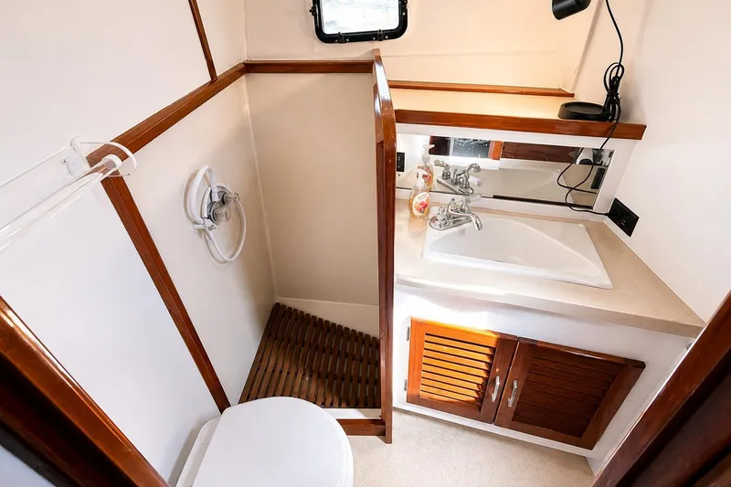 Slide: The Image of 1983 Silverton 402 Motor Yacht bathroom with sink, shower, and wooden accents. - 25