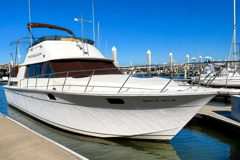 Slide: The Image of 1983 Silverton 402 Motor Yacht docked at marina under clear blue sky. - 1