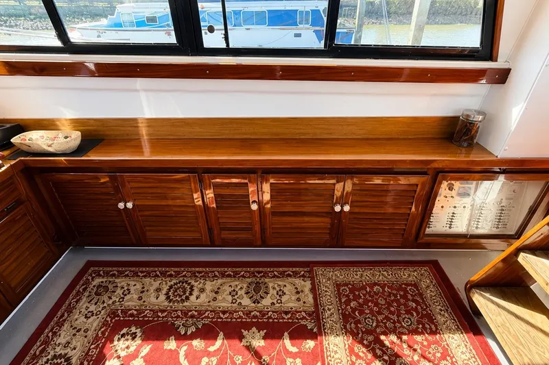 Slide: The Image of Interior of 1983 Silverton 402 Motor Yacht with wooden cabinetry and decorative rug. - 14