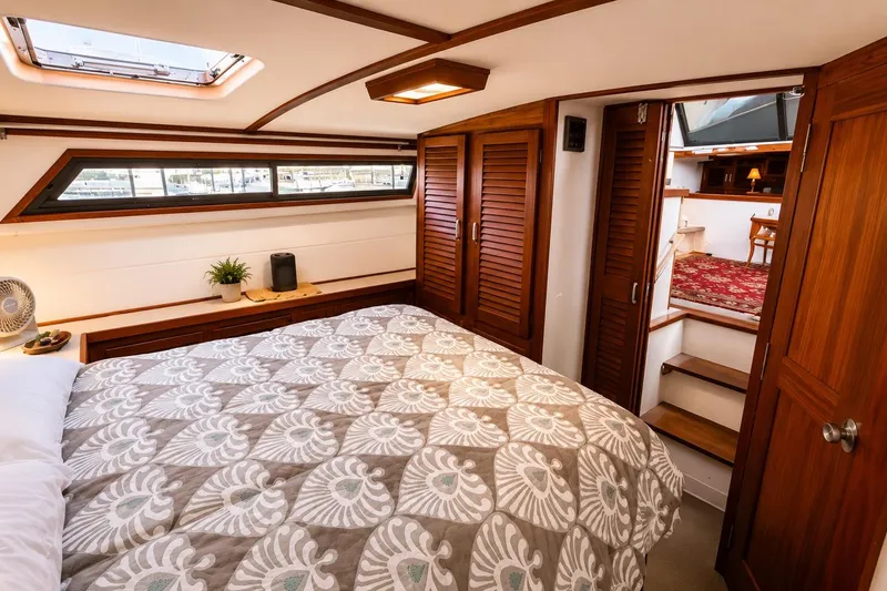 Slide: The Image of Luxurious bedroom interior of 1983 Silverton 402 Motor Yacht with wood accents and cozy bedding. - 22