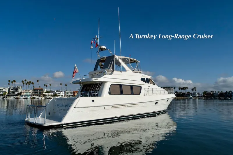 Slide: The Image of 2004 McKinna 57 Pilothouse yacht cruising in a serene harbor setting. - 1