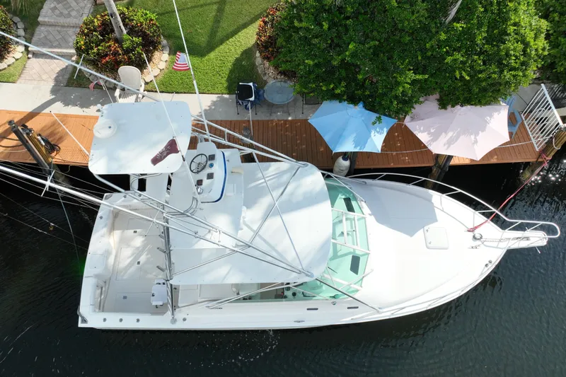 Slide: The Image of Aerial view of 2002 Cabo 35 Express boat docked near a lush garden. - 9
