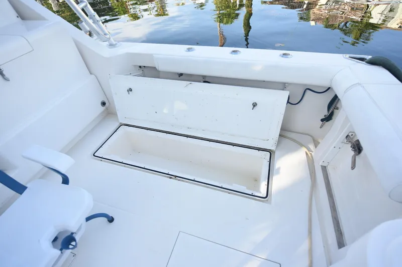 Slide: The Image of 2002 Cabo 35 Express boat interior with open storage compartment and seating. - 23