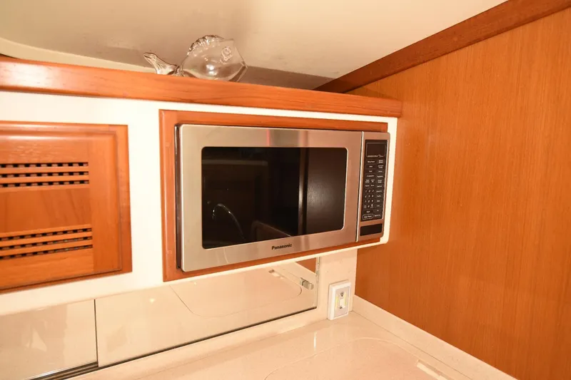 Slide: The Image of Microwave in 2002 Cabo 35 Express yacht kitchen with wooden cabinetry. - 88