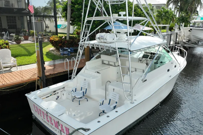 Slide: The Image of 2002 Cabo 35 Express boat docked near a lush garden and waterfront home. - 5