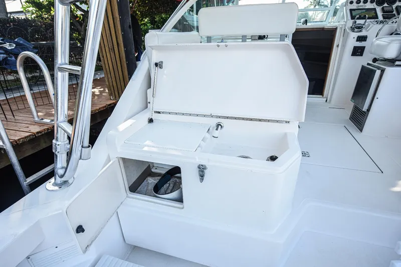 Slide: The Image of 2002 Cabo 35 Express boat interior with open storage compartment and seating area. - 30