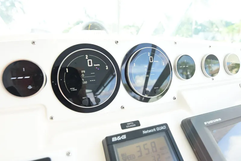 Slide: The Image of Dashboard of a 2002 Cabo 35 Express boat with gauges and navigation equipment. - 60