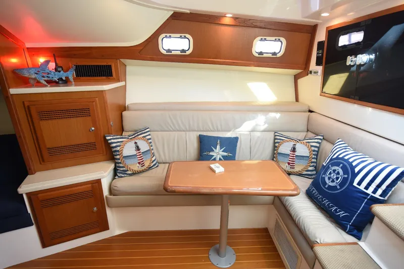 Slide: The Image of Interior of 2002 Cabo 35 Express yacht with nautical-themed cushions and wooden cabinetry. - 81