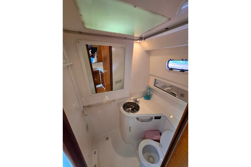 Slide: The Image of Compact bathroom in 2002 Cabo 35 Express yacht with sink, toilet, and mirror. - 92
