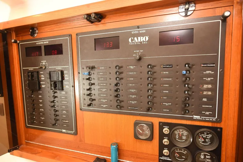 Slide: The Image of Electrical control panel of a 2002 Cabo 35 Express yacht, featuring various switches and gauges. - 96