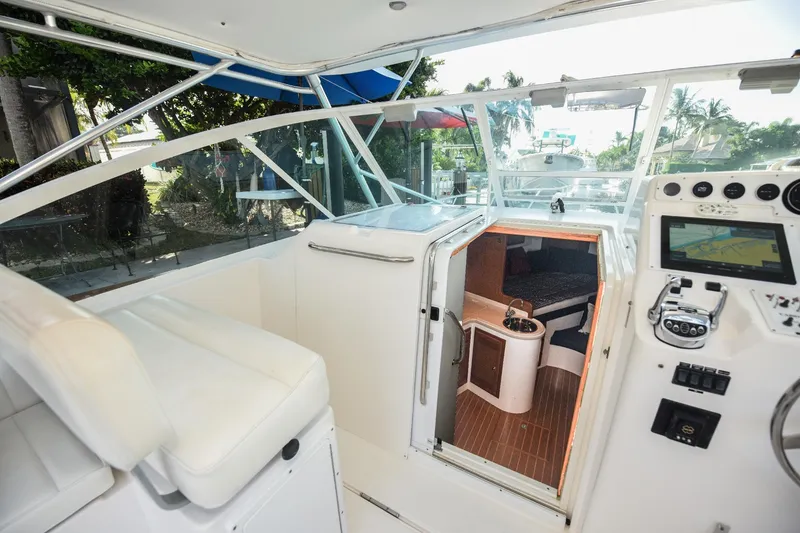 Slide: The Image of Interior view of a 2002 Cabo 35 Express boat, featuring helm and cabin entrance. - 52