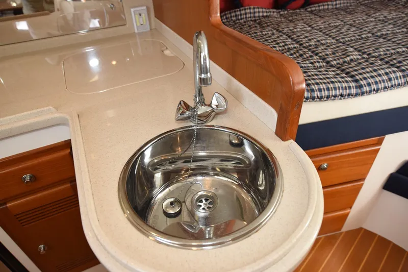 Slide: The Image of 2002 Cabo 35 Express yacht interior with sink and cozy cabin bed. - 86