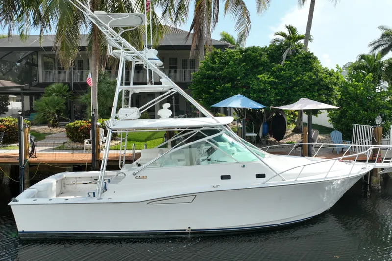 Slide: The Image of 2002 Cabo 35 Express boat docked by tropical waterfront home. - 2