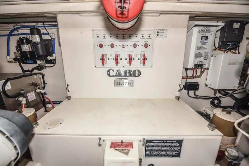 Slide: The Image of Engine room of a 2002 Cabo 35 Express boat, featuring control panels and wiring. - 105