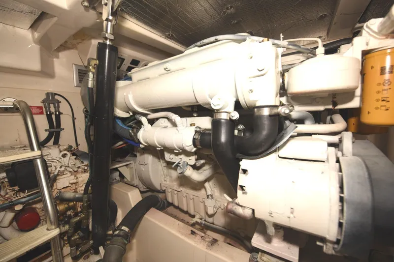 Slide: The Image of Engine room of a 2002 Cabo 35 Express boat, showcasing mechanical components and piping. - 104