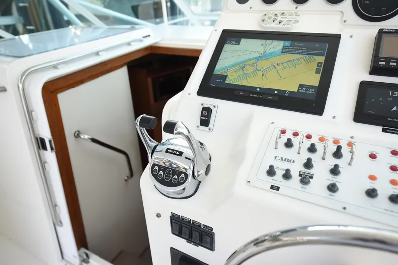 Slide: The Image of Control panel of a 2002 Cabo 35 Express boat with navigation display and throttle. - 56