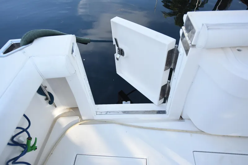 Slide: The Image of Open hatch on 2002 Cabo 35 Express boat, showing water reflection and deck details. - 20