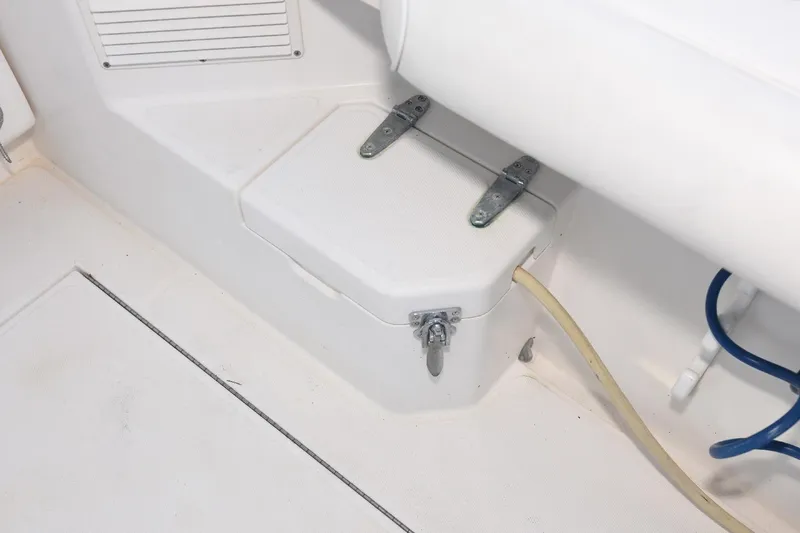 Slide: The Image of 2002 Cabo 35 Express boat interior detail with storage compartment and hose connections. - 25