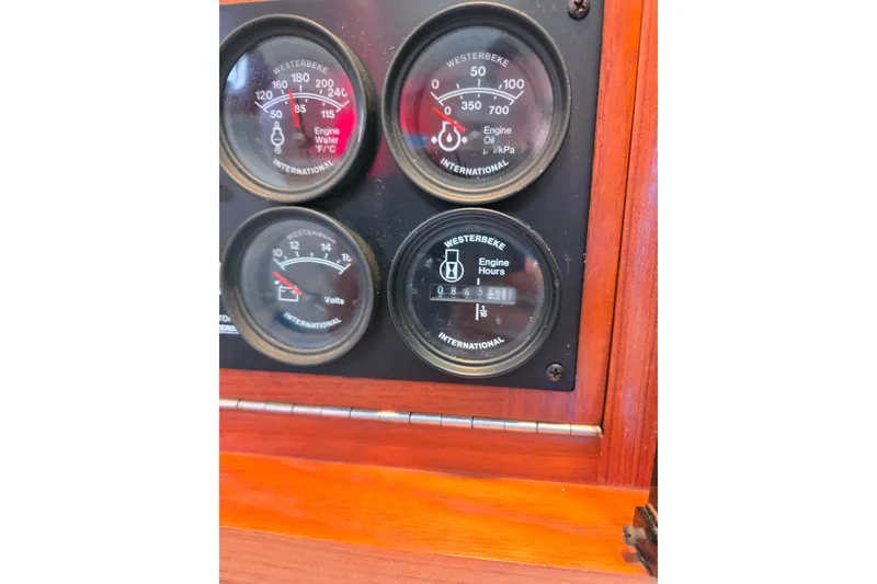 Slide: The Image of Close-up of 2002 Cabo 35 Express engine gauges, displaying water temperature, oil pressure, volts, and engine 843 hours. - 100